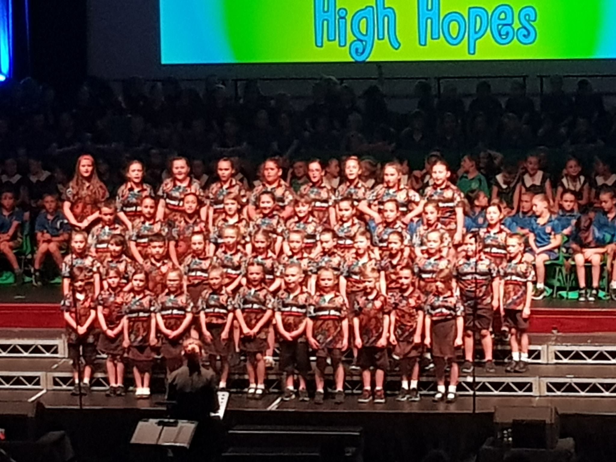 school choral group performing on stage at festival