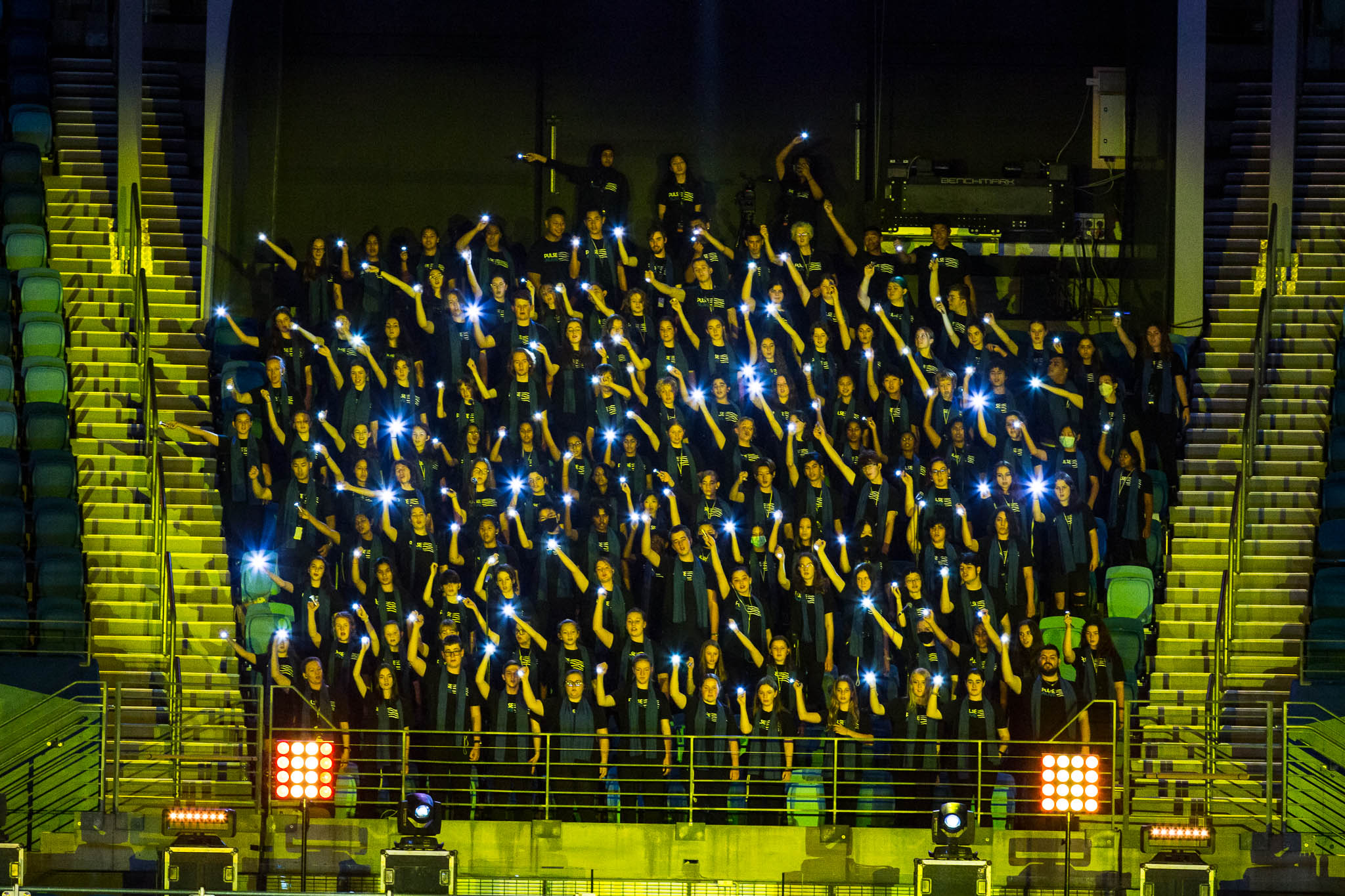 Massed choir in seating wearing black 