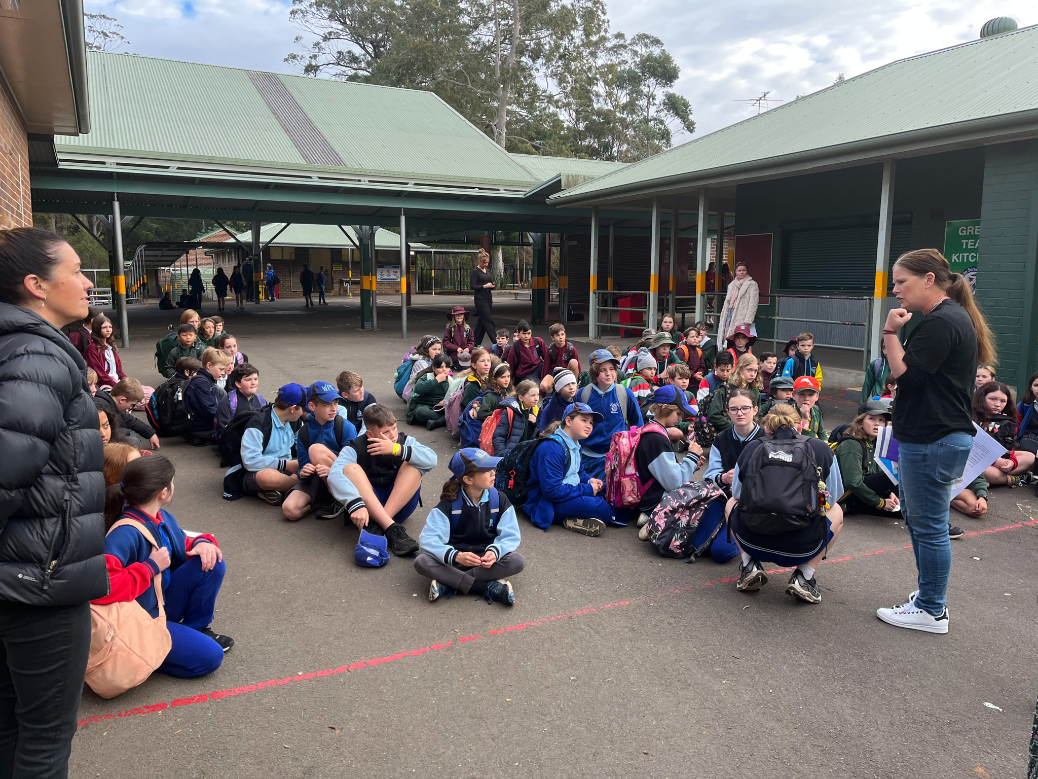 Students sitting in lines on the school playground at Gala Day.