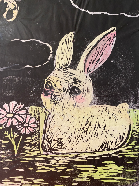 Lino print of a rabbit and flower in the moonlight using a black background and yellow and pink for the print
