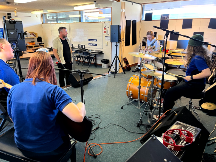 High school band performing in workshop to tutors