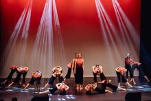 James Fallon High School dancers in black and red dresses under straks of white lights