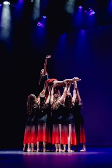 Leeton High School dancers in red to black ombre dresses lifting one student