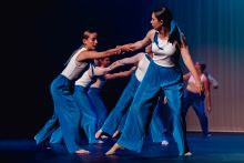 Temora High students wearing blue pants and white tops dancing in pairs with one pulling the other and