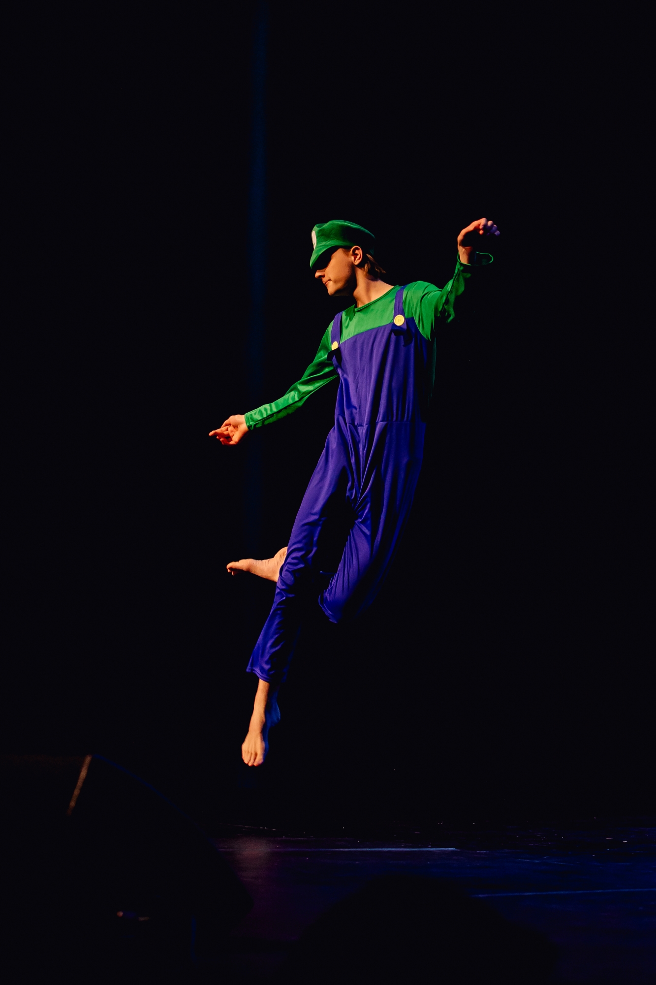 Wagga Wagga High School Learning Support dancer in blue overalls and green top leaping into the air