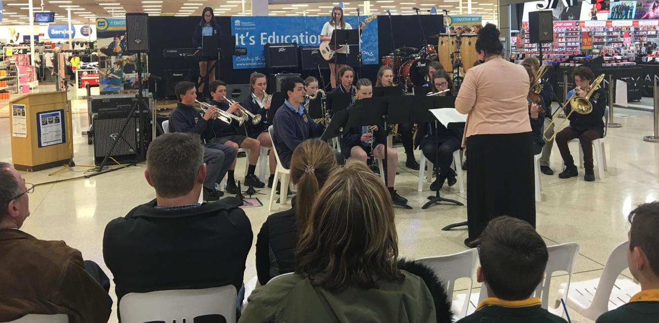 school band performing in marketplace in front of community audience