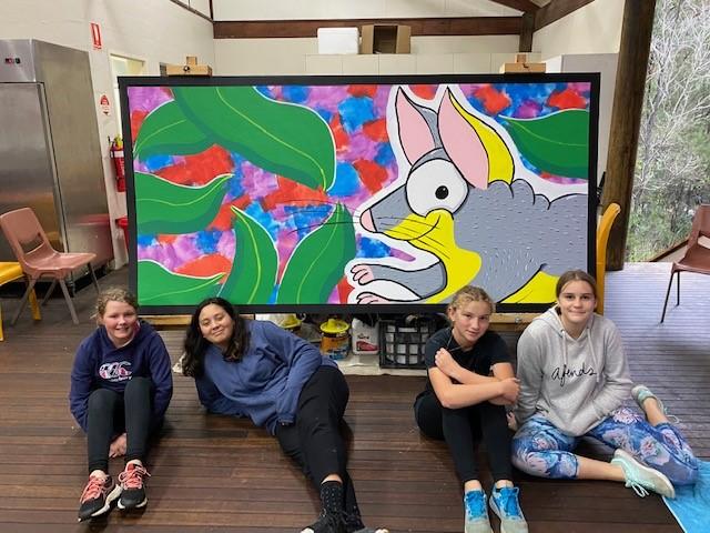 4 students in front of mural art of possum 