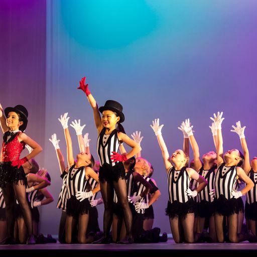 primary dancers on stage in black and white stripe costumes
