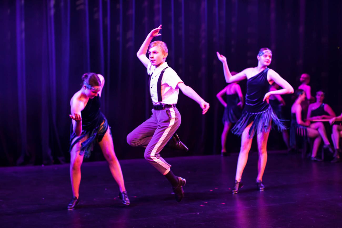 male dancers and 2 female dancers on stage
