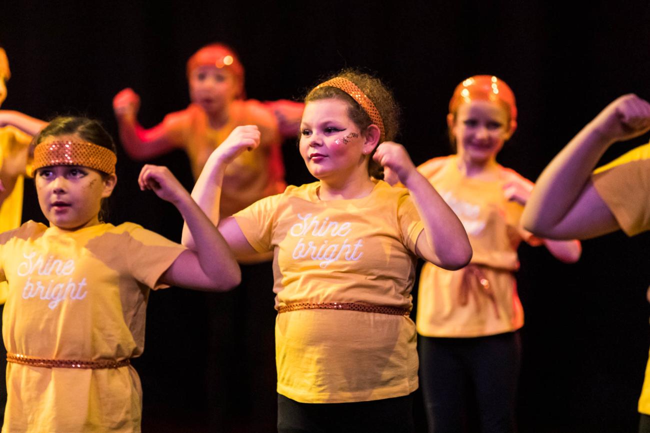 student dancers in yellow tshirts with sparkly headband