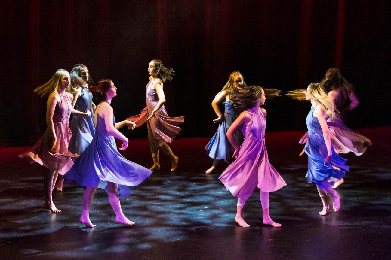 dancers spinning in a circle in coloured dresses