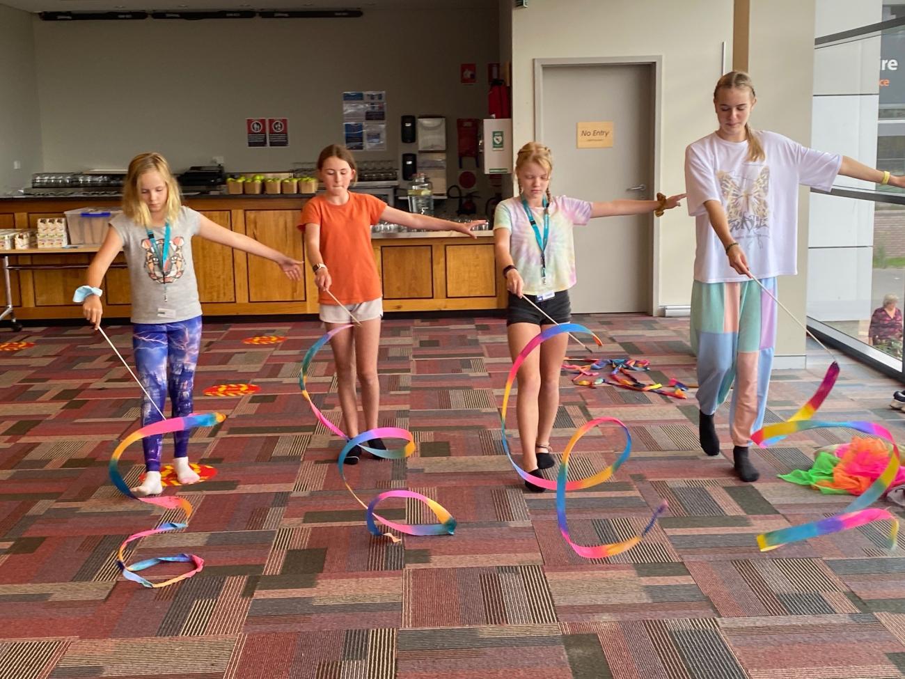 4 students twirling rhythmic ribbons