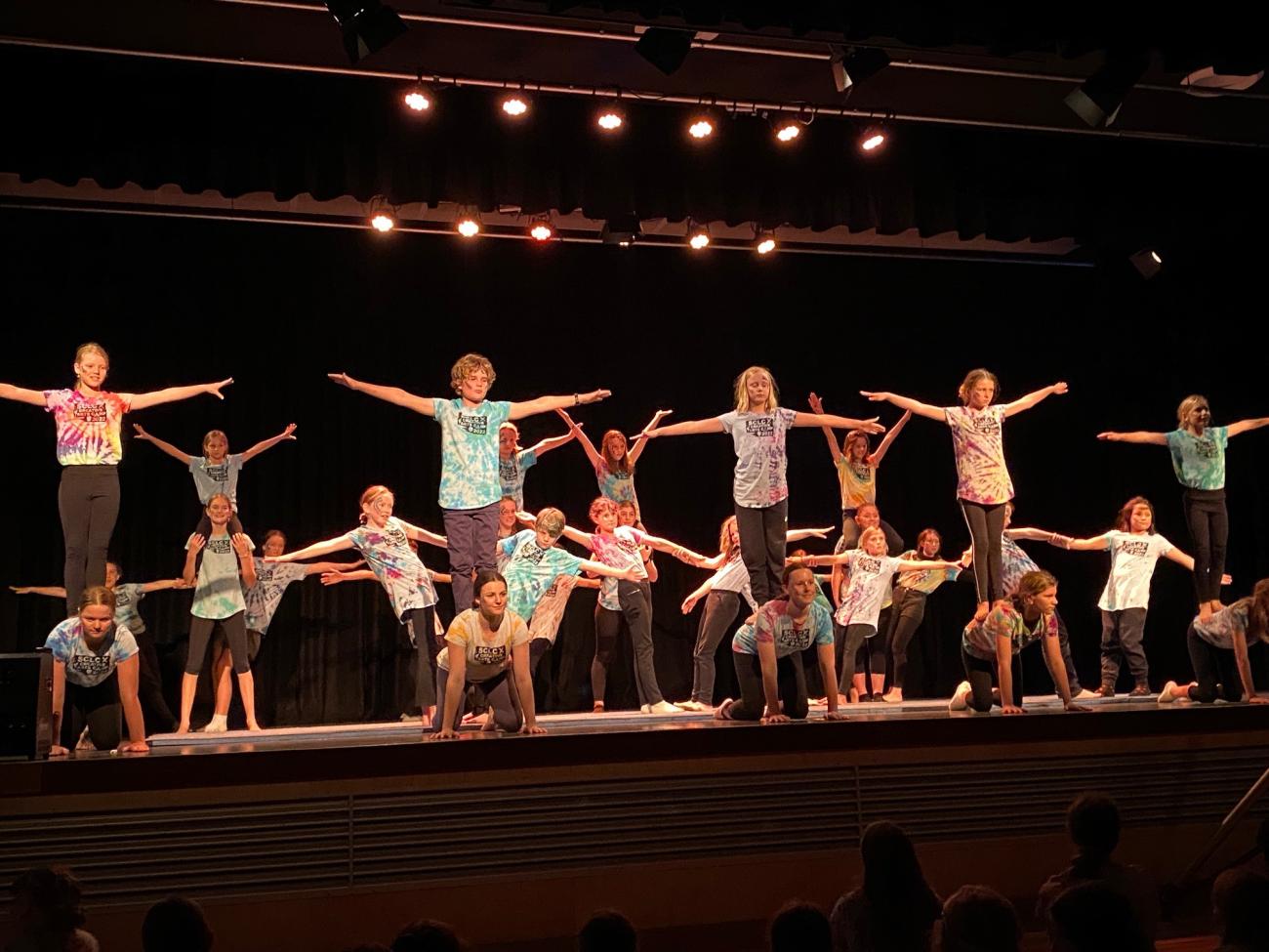 group of students performing adagio - one student on all 4's with partner standing on their back with arms outstretched