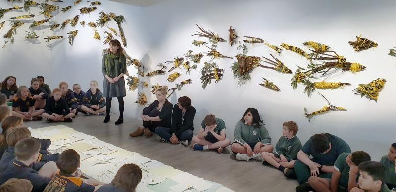 Students participating in a Home program workshop in an art gallery.