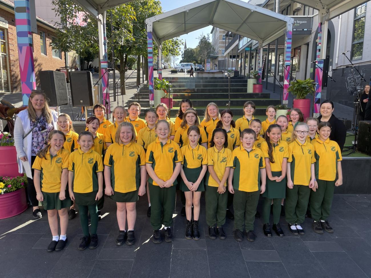 Warilla Public School Choir standing in front of the stage in school uniform for photo