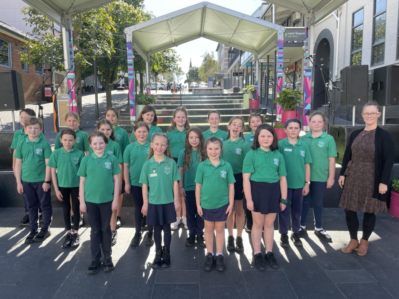 Primbee Public School Choir standing in front of the stage in school uniform for photo