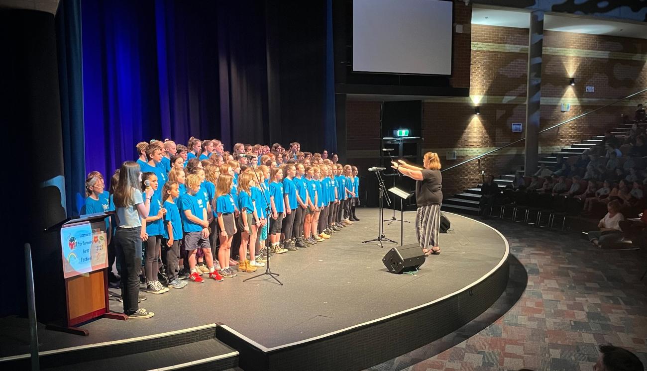 Primary school students singing in a choir on stage