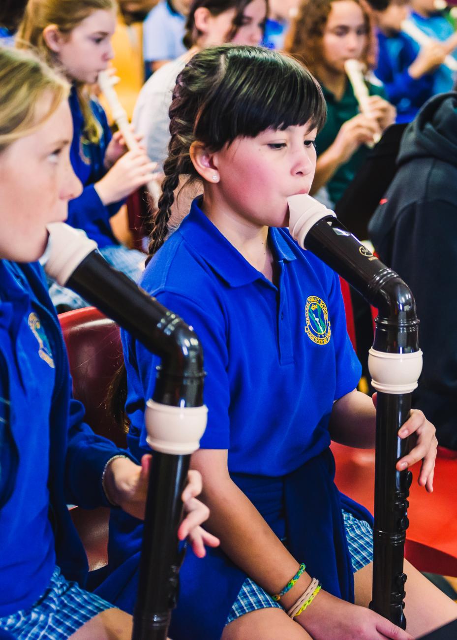 two primary school girls playing recorder