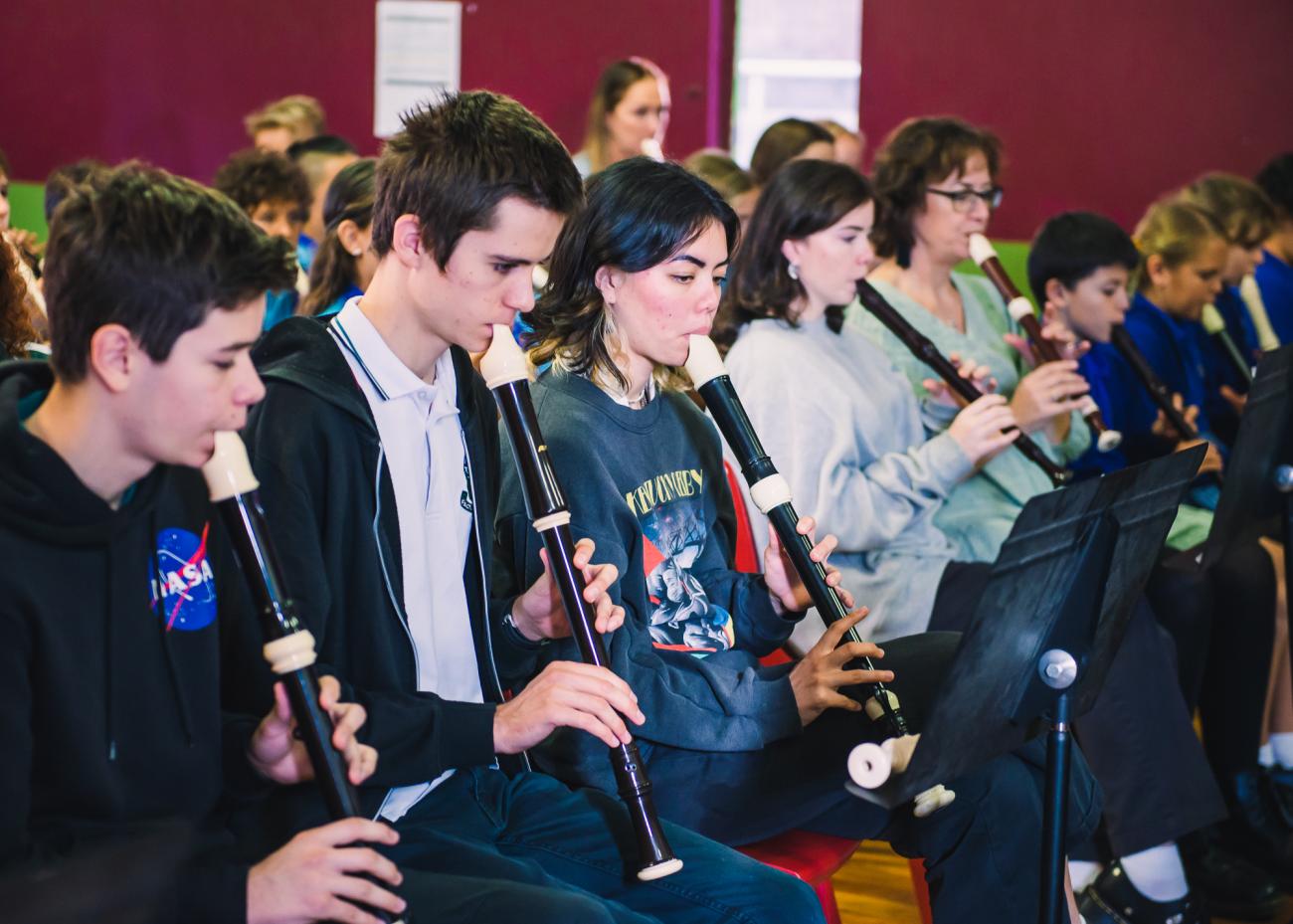 Secondary school students playing recorder