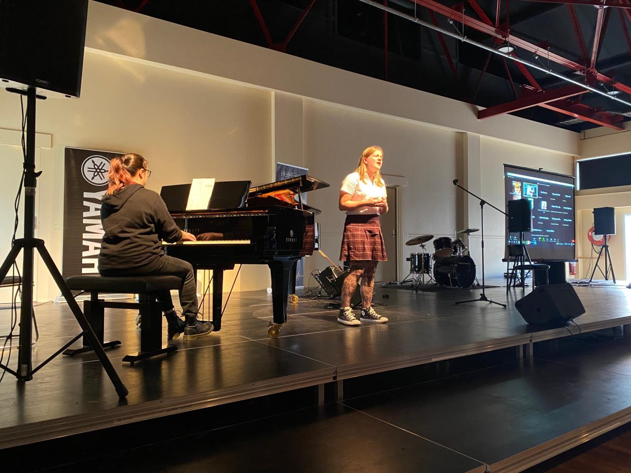 student performing on stage with piano accompanist at study day