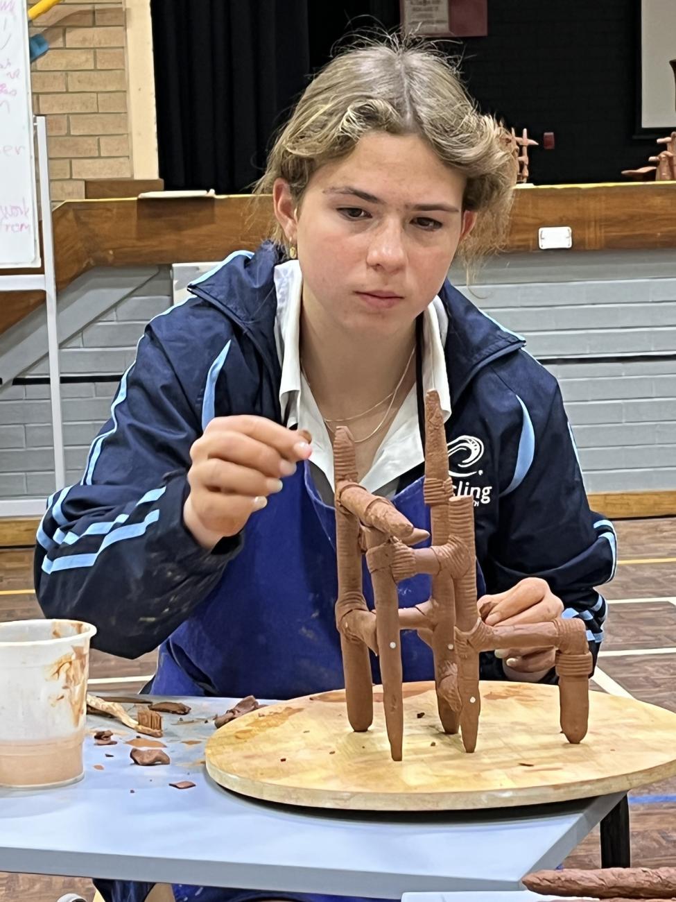 student working on clay sculpture