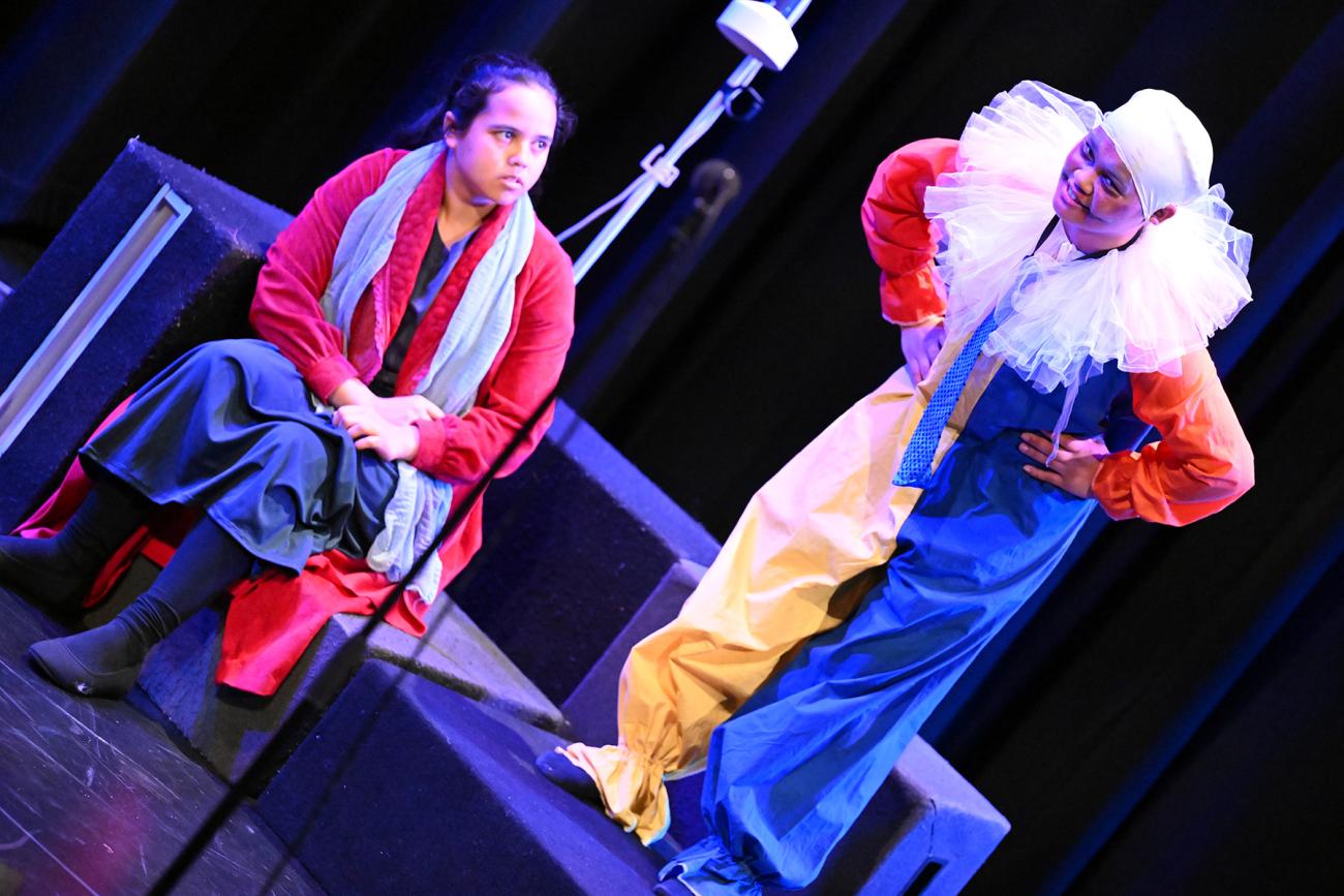 2 students on stage interacting with each other one dressed as a clown