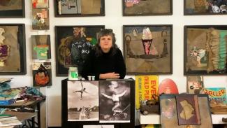 Karla Dickens standing with her artworks in her studio