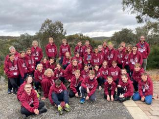 large group of students posing for picture in camp hoodies