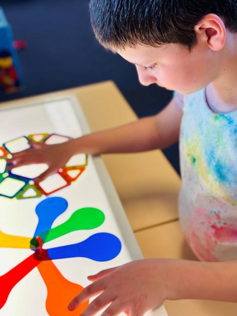 A student plays with 2 colourful fidget spinners.