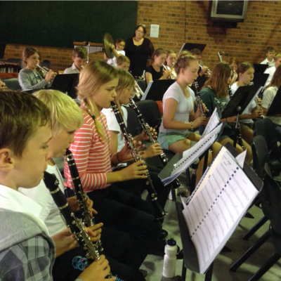 large group of students playing instruments looking at their sheet music