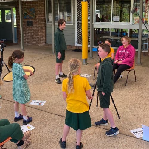 Group of students filming a scene with cameras and a boom microphone