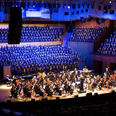 A large choir and stringed ensemble of students performing at the Concert Hall, Sydney Opera House